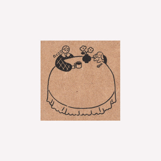Rubber journalling stamp with a frame design of a dining table with a girl and bunny drinking tea. 