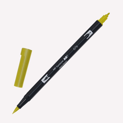 Tombow ABT Dual brush pen in Green Ochre (076) with open caps showing a fine tip for details and a brush tip for expressive marks.