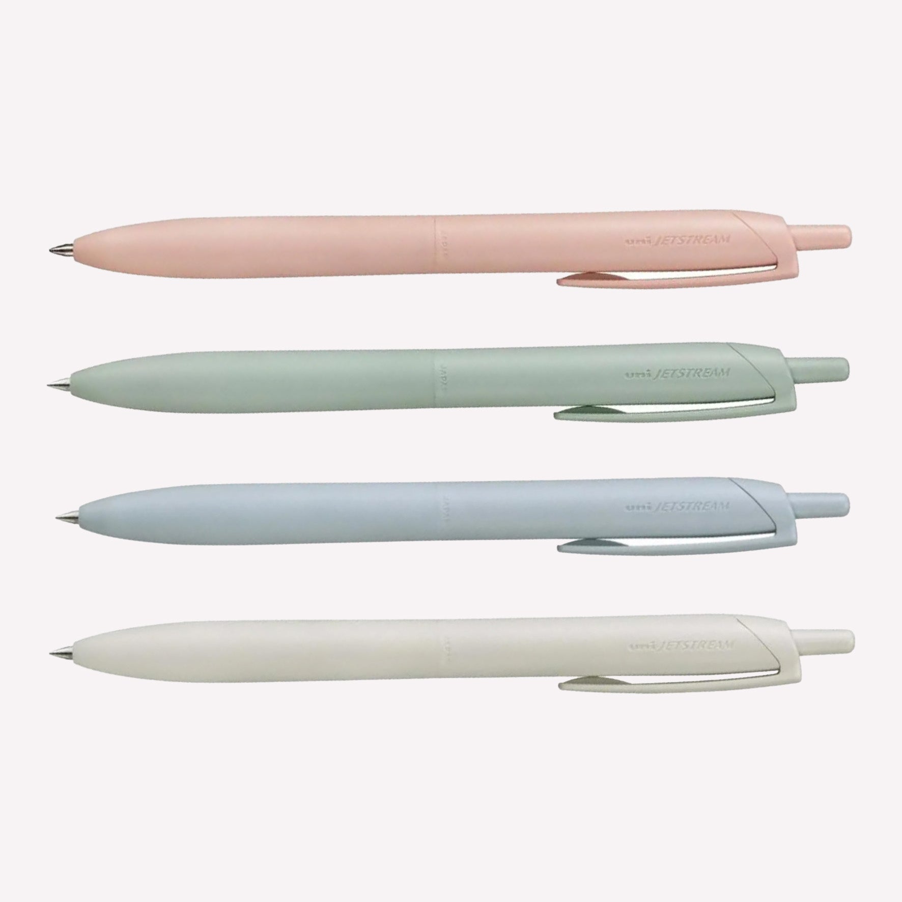 Uni Jetstream Lite Touch gel pens on a white background available in coral pink, sage green, light blue and shell white. 
