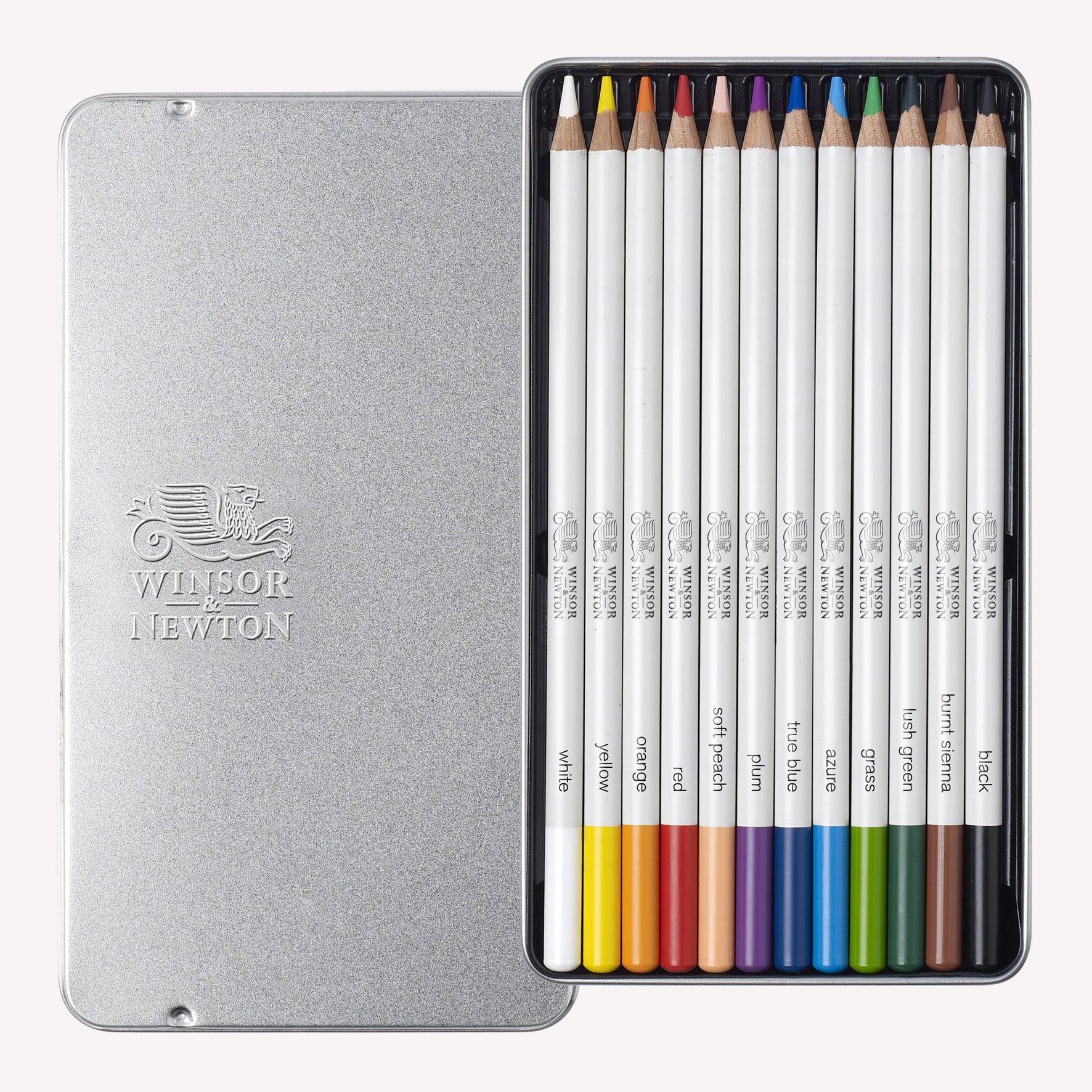An open metal silver tin containing Winsor and Newton’s Set of 12 Studio Collection Watercolour pencils. Coloured pencils included in the set are white, yellow, orange, red, soft peach, azure, plum, lush green, true blue, grass, burnt Sienna and black. 