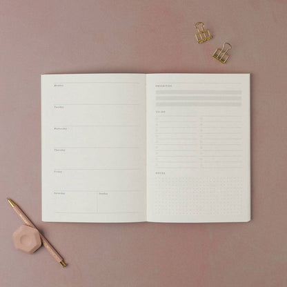 Open planner from Sister Paper Co showing the weekly page layout.