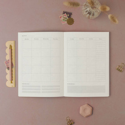 Open planner from Sister Paper Co showing the monthly calendar layout.