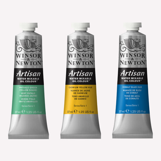 A set of three 37ml tube of Winsor & Newton, Artisan Water Mixable Oil Paint packaged in silver tubes with a black lid. Made with high quality pigments, the featured colours are Phthalo Green, Cadmium Yellow Hue and Cobalt Blue Hue.  