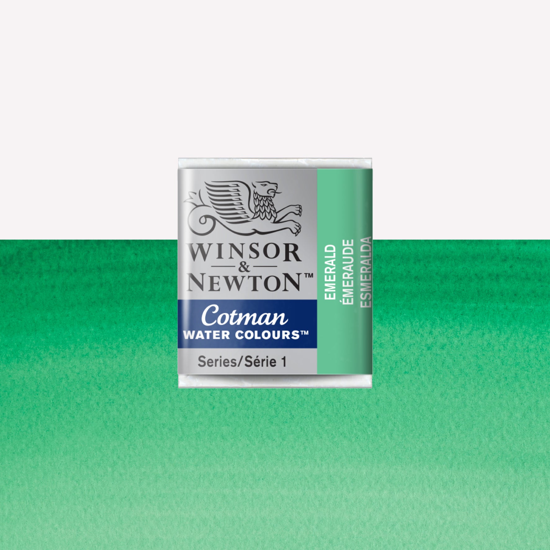 Winsor & Newton Cotman watercolour half pan in the shade Emerald over a vibrant colour swatch. These half pans have a solid formula and are packaged in compressed paint cake. 