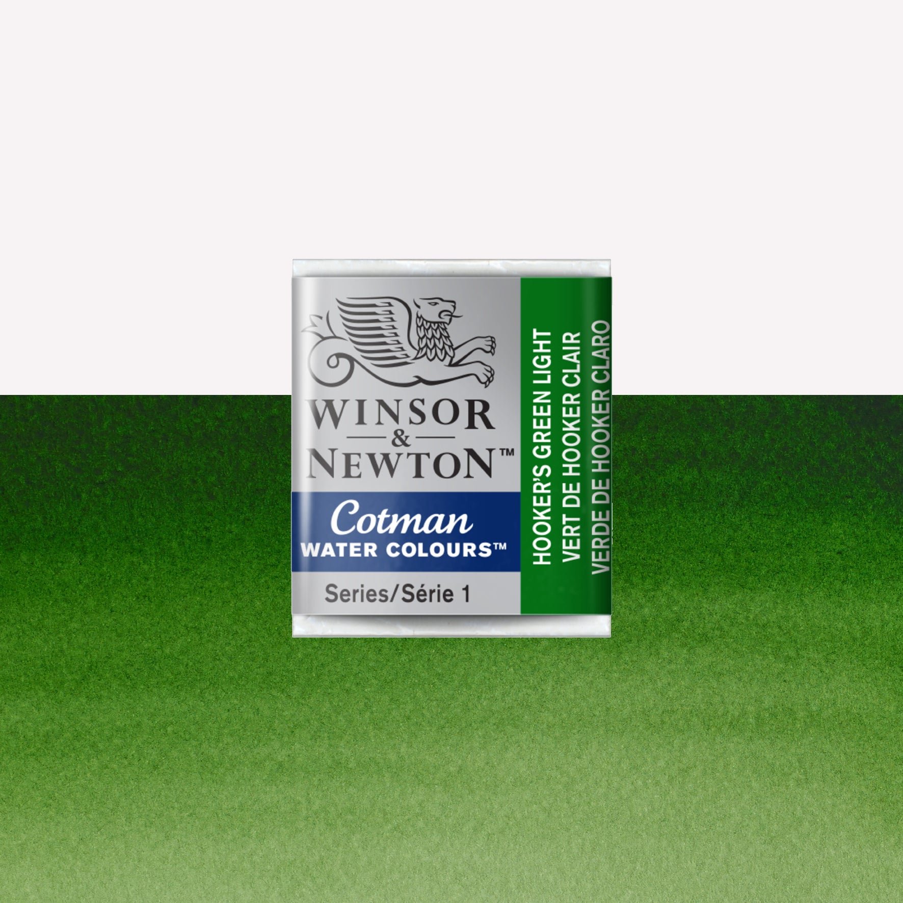 Winsor & Newton Cotman watercolour half pan in the shade Hooker’s Green Light over a vibrant colour swatch. These half pans have a solid formula and are packaged in compressed paint cake. 