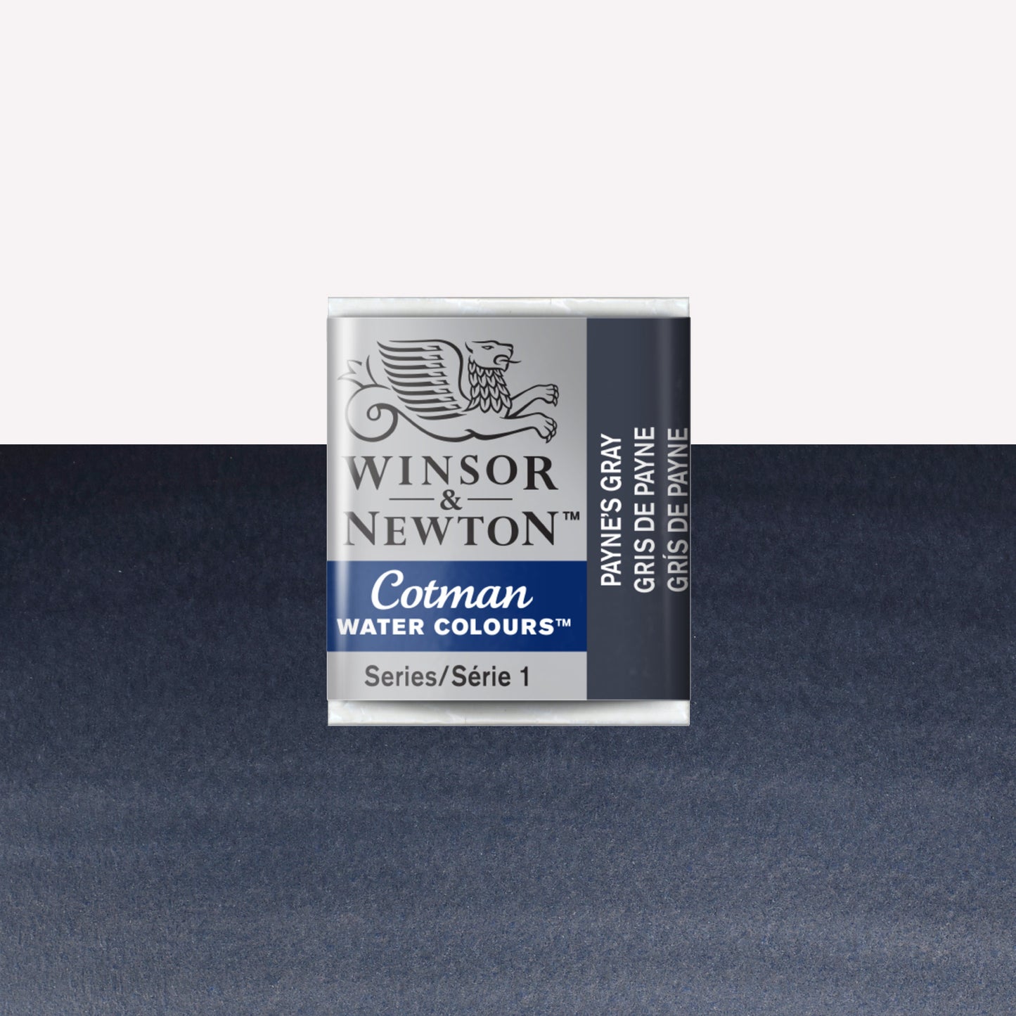 Winsor & Newton Cotman watercolour half pan in the shade Payne’s Grey over a vibrant colour swatch. These half pans have a solid formula and are packaged in compressed paint cake. 